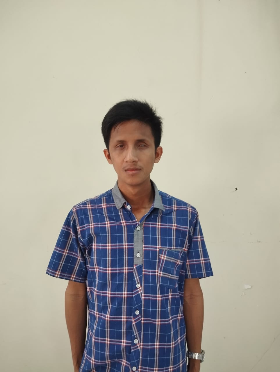 Alfian Andhika Yudhistira mengenakan kemeja biru kotak-kotak